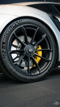 a close up of the wheels of a white sports car