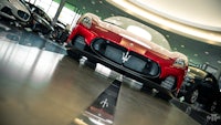 a red maserati sports car in a showroom